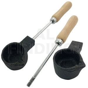 Peut inclure: Deux louches de fusion en fonte noire avec des manches en bois. Chaque louche a un bol rond, un bec verseur et une longue tige métallique argentée. Les manches en bois sont brun clair.