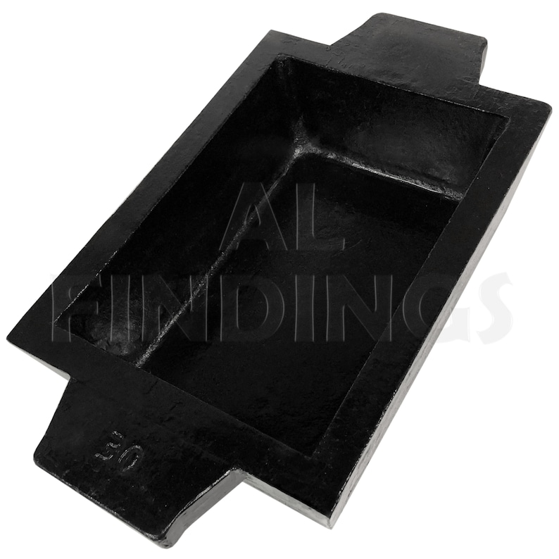 May include: A black metal casting mold with a rectangular shape and two handles. The mold is marked with the number "50".