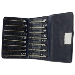 May include: A black leather case containing a set of drill bits. The case is open, revealing the drill bits arranged in rows, labelled with their sizes in millimetres. The sizes range from 1.05 mm to 2.00 mm.