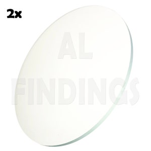 Puede incluir: Dos discos de vidrio redondos y transparentes con el texto "AL FINDINGS" impreso en ellos.
