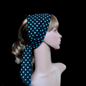 Peut inclure: Un foulard noir &agrave; pois bleu clair. Le foulard est nou&eacute; autour de la t&ecirc;te et du cou d'un mannequin, avec les extr&eacute;mit&eacute;s pendantes. Le fond est noir.