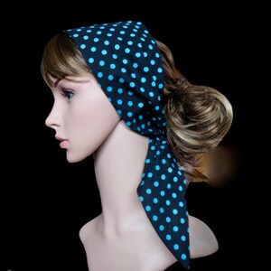 Peut inclure: Un foulard noir &agrave; pois bleu clair. Le foulard est nou&eacute; autour de la t&ecirc;te d'un mannequin, avec les extr&eacute;mit&eacute;s pendantes. Le fond est noir.