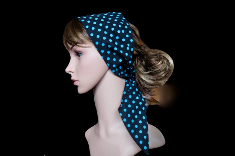 Peut inclure: Un foulard noir &agrave; pois bleu clair. Le foulard est nou&eacute; autour de la t&ecirc;te d'un mannequin, avec les extr&eacute;mit&eacute;s pendantes. Le fond est noir.