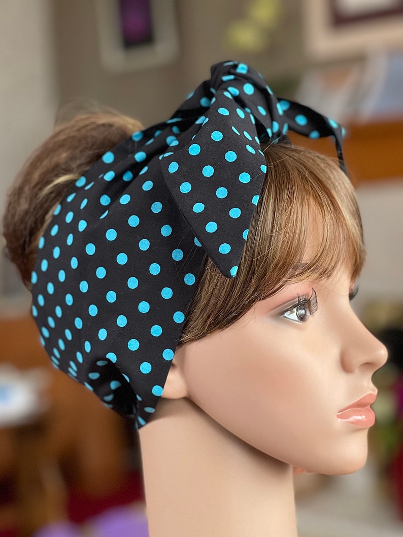 Peut inclure: Un foulard noir &agrave; pois bleu clair. Le foulard est nou&eacute; en n&oelig;ud sur le dessus de la t&ecirc;te. Le couvre-chef est sur une t&ecirc;te de mannequin.