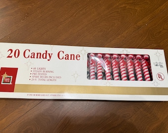 May include: A rectangular box containing 20 candy cane shaped lights. The white packaging features red text reading 20 Candy Cane, 40 lights, steady burning, pre-tested, spare bulbs included, and 20 ft. total length, with a clear window showing the lights.