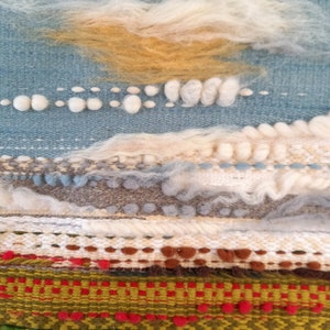 Puede incluir: Obra de arte textil con dise&ntilde;o de paisaje. Presenta un cielo azul claro con nubes blancas y amarillo dorado. Debajo, capas texturizadas de tejido en tonos verdes, rojos y marrones.