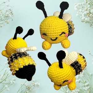 May include: Three crocheted bee plushies with black antennae, yellow bodies, and black and white wings. The bees have smiling faces with pink cheeks.