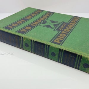 May include: A green hardcover book titled "1001 Ways To Improve Your Photographs". The book has gold lettering and a black and gold design on the spine.