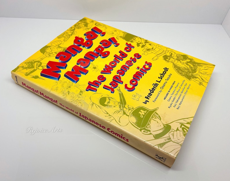 Puede incluir: Un libro amarillo titulado "Manga! El mundo del c&oacute;mic japon&eacute;s" de Frederik L. Schodt. La portada presenta ilustraciones de personajes de manga y el texto "Pr&oacute;logo de Osamu Tezuka".
