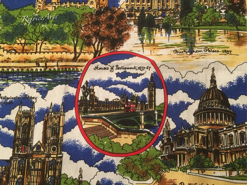 May include: A colorful fabric with a pattern of famous London landmarks, including Buckingham Palace, Houses of Parliament, and Westminster Abbey. The fabric features a blue and white background with red, yellow, and green accents.
