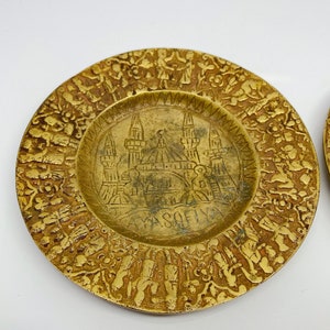 May include: A brass plate with an intricate design featuring a mosque and the word "Sofia". The plate is decorated with a border of stylized figures and floral motifs.