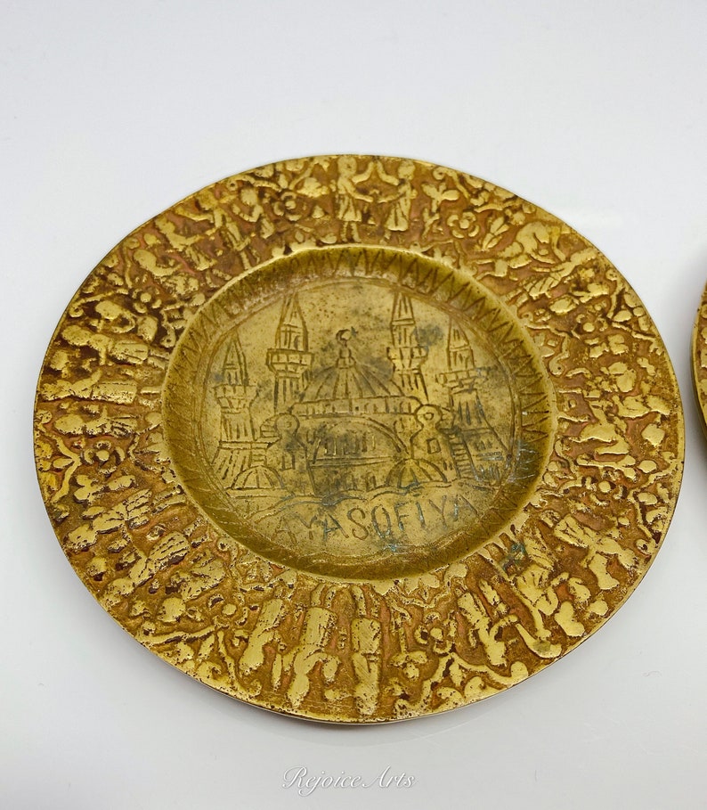 May include: A brass plate with an intricate design featuring a mosque and the word "Sofia". The plate is decorated with a border of stylized figures and floral motifs.