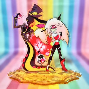 May include: A clear acrylic stand featuring two cartoon characters. One character is a tall figure in a black suit with yellow accents and a top hat. The other is a character with white hair, red clothing, and black pants. The stand has a gold-colored base.