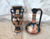 Set of two amphora shape vases, in black glaze with red figured designs.