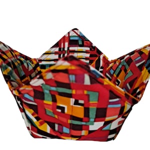 May include: A red, yellow, and black fabric bowl with a geometric pattern. The bowl is folded and ready to be used.
