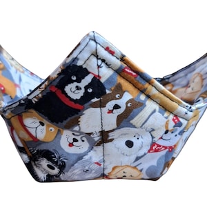 Puede incluir: Un cuenco de tela blanco con un diseño de estampado de perros. El cuenco está hecho de tela y tiene una forma triangular. El cuenco es perfecto para guardar aperitivos, llaves u otros objetos pequeños.