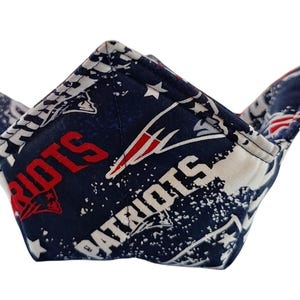 Könnte beinhalten: Eine blaue und weiße Stoffschale mit einem rot-weißen Patriots-Logo und dem aufgedruckten Wort "Patriots".