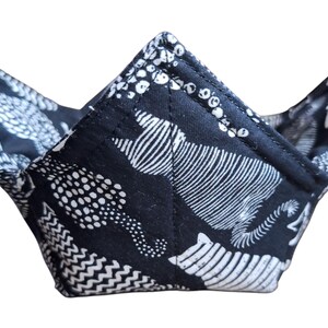 May include: A black and white patterned fabric bowl, made from cotton, with a geometric design. The bowl is folded and ready to be used.