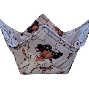 May include: A gray fabric bowl with a white background and a pattern of cartoon nurses in white uniforms. The nurses are all women with brown skin and black hair.