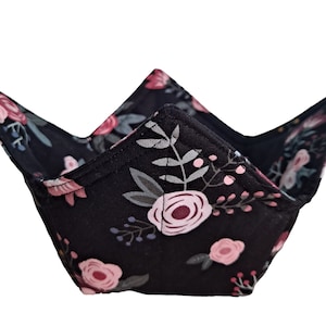 Puede incluir: Un cuenco de tela negro con un patrón floral en tonos de rosa y verde. El cuenco está doblado en forma triangular.