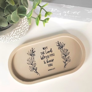 May include: A beige oval tray with a black floral design and the text "May the Lord bless you & keep you, Numbers 6:24".