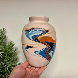 May include: A set of three ceramic mugs with a speckled, matte finish. The mugs are in shades of cream, light gray, and dark gray. Each mug has a simple, minimalist design, perfect for coffee or tea.