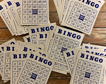 May include: A stack of beige bingo cards with blue lettering. The cards have numbers 1-75 and the word "Bingo" at the top. The cards are arranged in a random order.