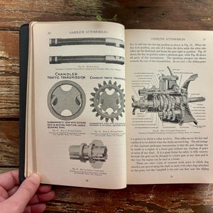 May include: Open vintage book pages with diagrams and text about gasoline automobiles and Chandler traffic transmission. The pages are black and white with detailed illustrations of car parts.
