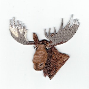 以下が含まれることがあります： 茶色のヘラジカの頭と大きな角の刺繍パッチ。角は薄い茶色で、先端は白くなっています。