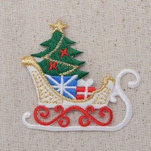 May include: White embroidered Christmas sleigh with a green Christmas tree and red and blue presents. The sleigh has gold trim and red and white swirls.