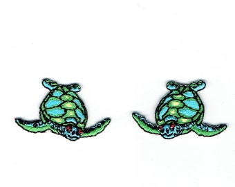 May include: Two green and blue embroidered sea turtle patches with red eyes.
