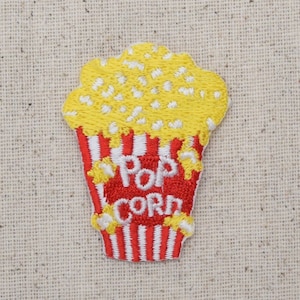 May include: Embroidered iron-on patch featuring a red and white striped popcorn bucket with yellow popcorn and the text "Pop Corn".
