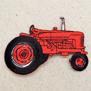 May include: Red embroidered tractor patch with black wheels and a white exhaust pipe.