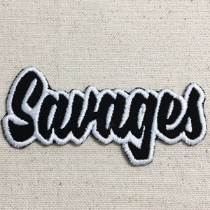 Peut inclure: Patch brodé noir et blanc avec le mot "Savages" dans une police stylisée.