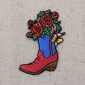 May include: Embroidered iron-on patch of a red cowboy boot with a bouquet of red, pink, and yellow flowers. The boot is blue and has a pointed toe.
