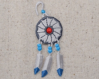 May include: A silver dreamcatcher with blue and white beads and three white feathers. The dreamcatcher has a white centre with a red dot.