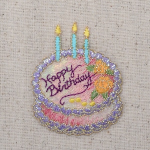 May include: Embroidered birthday cake patch with the words "Happy Birthday" in purple script. The cake has pink and white layers, adorned with yellow and orange flowers, three blue candles with yellow flames, and a gold border.