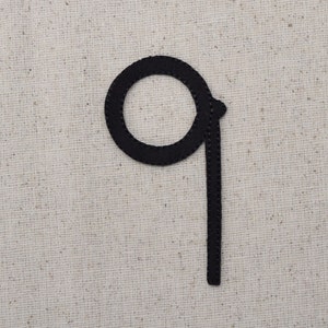 May include: Black felt number nine, with a circle for the top part and a straight line for the bottom part.