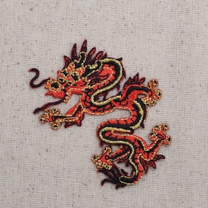 Op de afbeelding: Rode en zwarte geborduurde strijk-op-patch van een Chinese draak met gouden accenten.