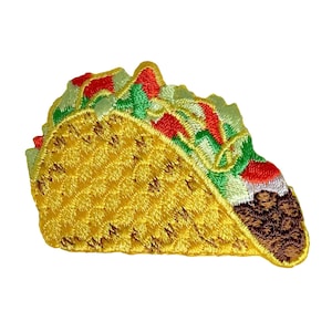 May include: A yellow embroidered taco with green lettuce, red tomatoes, and brown meat filling.