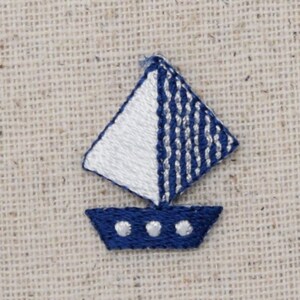 May include: A small blue and white embroidered sailboat with three white dots on the hull.