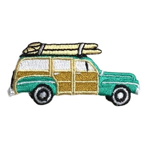 May include: An embroidered patch of a green vintage station wagon with wood paneling. The car has a roof rack with two surfboards on top.
