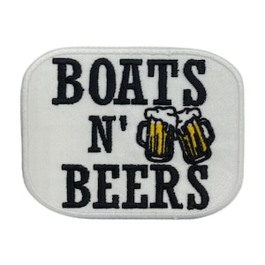 May include: White embroidered patch with black text that reads "BOATS N' BEERS" with two yellow and brown beer mugs with foam on top.