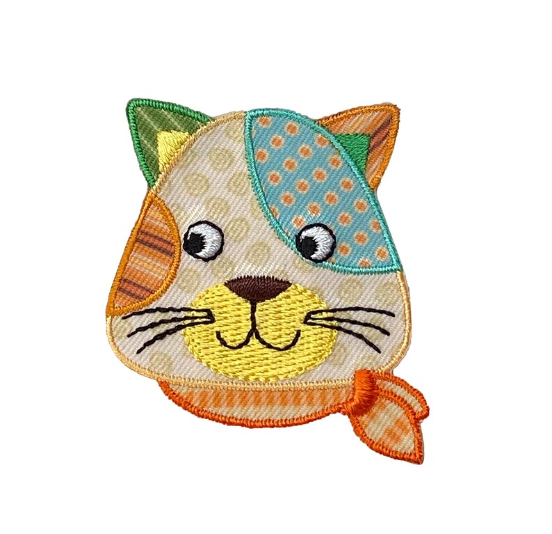 May include: A colorful embroidered cat face patch with a yellow smile, orange and white striped ears, and a blue and white polka dot patch on the head. The cat is wearing a yellow and orange scarf.