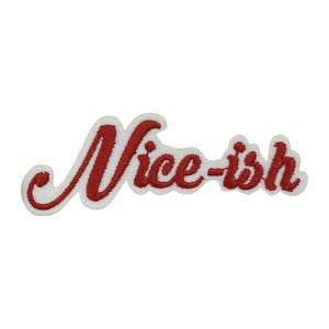 May include: Embroidered patch featuring the word "Nice-ish" in red script on a white background. The patch is curved and designed to be ironed or sewn onto clothing or accessories. The patch is likely for decorative purposes.