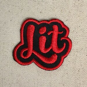 Op de afbeelding: Rode geborduurde patch met het woord "lit" in een gestileerd lettertype.