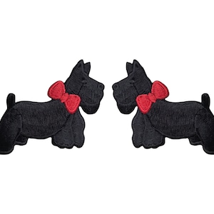 Könnte beinhalten: Zwei schwarze Filz-Applikationen mit einem schottischen Terrier, der eine rote Schleife trägt. Die Applikationen sind einander zugewandt.