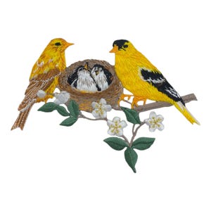 May include: Embroidered patch of a yellow bird family. The mother bird is perched on a branch with a nest of baby birds. The nest is surrounded by white flowers and green leaves.