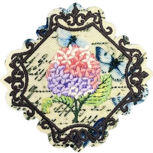 May include: Embroidered patch featuring a pink and purple hydrangea flower with green leaves, set against a background of blue butterflies and a vintage-style script. The patch is framed with a black ornate border.