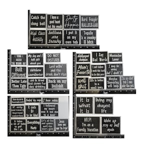 May include: A collection of black and white embroidered patches with various humorous phrases and quotes. The patches are rectangular and feature white text on a black background, with phrases like "Dirty Hippie" and "I'm on a Family Vacation."